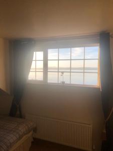 sypialnia z oknem z widokiem na ocean w obiekcie Ocean view B&B w mieście Ringville