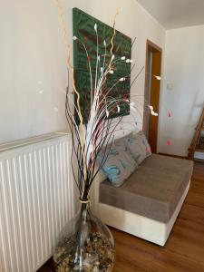 a vase with branches in a room with a bed at ★ Meniko's House ★ Amazing Sea View in Himare
