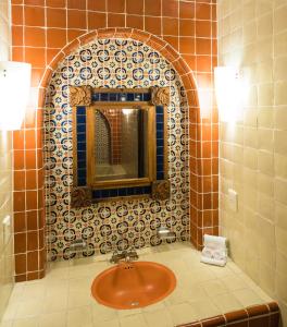 La salle de bains est pourvue d'un lavabo et d'un miroir. dans l'établissement Hotel Real de Naturales, à Cholula