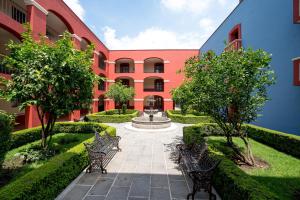 喬盧拉的住宿－Hotel Real de Naturales，一座庭院,里面设有两个长椅和一个喷泉