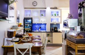 a kitchen with a wooden table with chairs and a counter at Blu Mediterraneo B&B in Messina