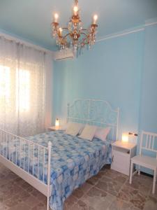 ein blaues Schlafzimmer mit einem Bett und einem Kronleuchter in der Unterkunft AuStrAle in Albenga