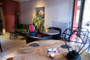 a restaurant with tables and chairs in a room at Logis Hôtel Restaurant Azalées in Tournon-sur-Rhône