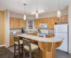 a kitchen with wooden cabinets and a white refrigerator at WorldMark Windsor in Windsor