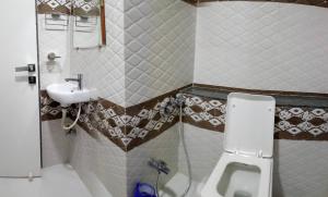 a small bathroom with a sink and a toilet at Hotel Shahi Darbar in Navsāri