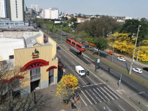 a view of a city street with a red bus at Hotel Itamaraty in Curitiba