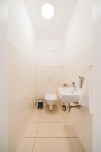 a white bathroom with a toilet and a sink at Apart SKY Residence Hauptbahnhof with Balcony in Vienna