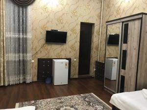 a room with two refrigerators and a tv on the wall at Real Tashkent in Tashkent