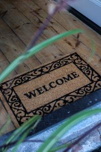 a welcome mat on a wooden floor with the word welcome at Mini appartement De Fabriek in Nijmegen