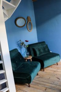 een woonkamer met een groene bank en een tafel bij Mini appartement De Fabriek in Nijmegen