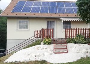 ein Haus mit einem Haus mit Sonnenkollektoren darauf in der Unterkunft House at Lake in Esztergom