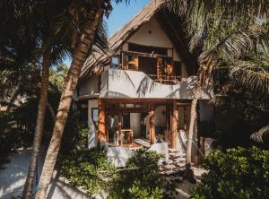 a house with palm trees in front of it at Beautiful house on beach zone Tulum in Tulum