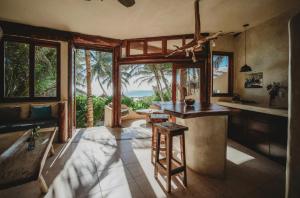a kitchen with a island in a room with windows at Beautiful house on beach zone Tulum in Tulum