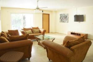 sala de estar con 2 sofás y TV en Hermoso Apartamento con Piscina/RoofGarden/Ac/ en Sayulita., en Sayulita