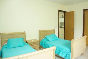 une chambre avec deux lits avec des draps bleus et un miroir dans l'établissement Hermoso Apartamento con Piscina/RoofGarden/Ac/ en Sayulita., à Sayulita 16 autres photos