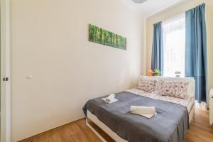 1 dormitorio con 1 cama con cortinas azules y ventana en Dohány Residency Inner City Synagogue, en Budapest