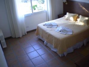 a bedroom with a bed with two towels on it at Montecassino in Capilla del Monte