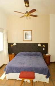 um quarto com uma cama azul e uma ventoinha de tecto em Montecassino em Capilla del Monte