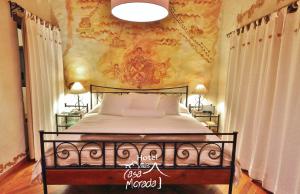 a bedroom with a bed with a painting on the wall at Hotel Villas Casa Morada in San Cristóbal de Las Casas