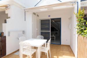 a dining room with a white table and chairs at bungalow with terrace near the beach in San Bartolomé de Tirajana