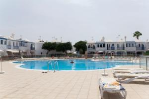 a large swimming pool with a person swimming in it at bungalow with terrace near the beach in San Bartolomé