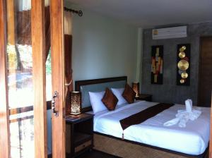 um quarto com uma cama com lençóis brancos em Lanta Happy Hill em Ko Lanta