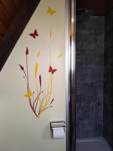 a bathroom with a painting of flowers and leaves on the wall at Eifeler Finnhaus mit Sauna, Mühlenberg 13 in Dockweiler