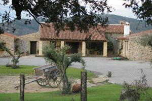 una casa con un banco delante de ella en Finca Los Caleros, en Juan Gallegos
