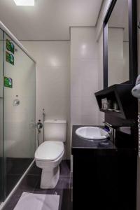 La salle de bains est pourvue de toilettes blanches et d'un lavabo. dans l'établissement San Silvestre Hotel, à Passo Fundo