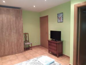 1 dormitorio con TV en un tocador y una silla en Casa rural Las Mareas, en Casas del Monte