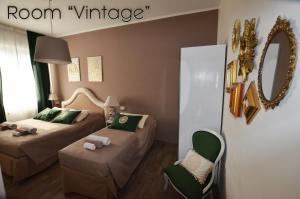 Pokój z 2 łóżkami, krzesłem i lustrem w obiekcie Room & Breakfast Nettuno 29 w Bolonii
