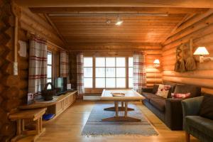 a living room with a couch and a table at Joutsen Holiday Home in Luosto