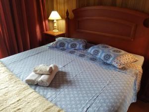 1 cama con 2 toallas y almohadas en Apartamento na Serra, en Canela