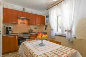 eine Küche mit einem Tisch und einer Obstschale darauf in der Unterkunft Apartment Lara in Mali Lošinj