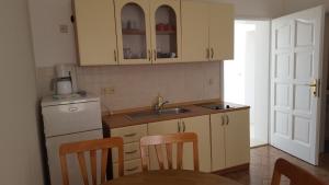 a kitchen with white cabinets and a table and chairs at Zagi in Povljana