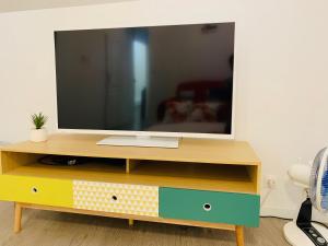 a tv on a wooden stand with a television on it at Le MonMon grand T2 hyper centre ville in Fontenay-le-Comte +4 photos