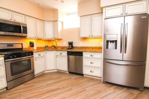 a kitchen with white cabinets and a stainless steel refrigerator at Luxury 3 Bedroom, 20 min to Boston, 15min Encore in Malden