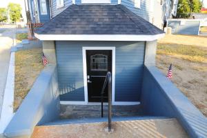 a blue house with a black door and american flags at Luxury 3 Bedroom, 20 min to Boston, 15min Encore in Malden