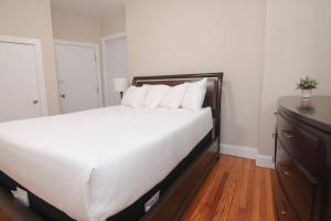 ein Schlafzimmer mit einem großen weißen Bett mit weißen Kissen in der Unterkunft Luxury 3 Bedroom, 20 min to Boston, 15min Encore in Malden