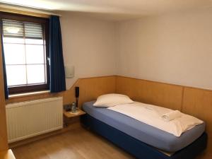 a small bedroom with a bed and a window at Gasthof zum Hirsch in Sachsenheim