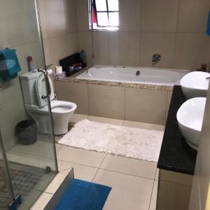 uma casa de banho com uma banheira, um WC e um lavatório. em Robert's Place Paarl em Paarl