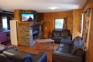 sala de estar con muebles de cuero y chimenea de piedra. en Au Beolin, en Houffalize