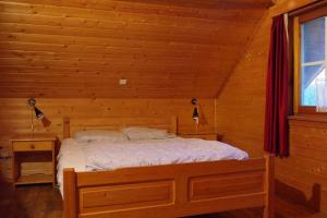 una camera con un letto in una baita di tronchi di Au Beolin a Houffalize