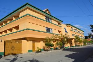 un gran edificio amarillo con palmeras delante en Peten Esplendido, en Flores
