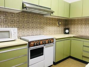 a kitchen with a stove and a microwave at Casa do Nini in Amarante