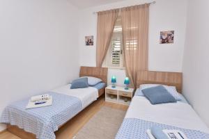a bedroom with two beds and a window at Apartments Dragica in Primošten