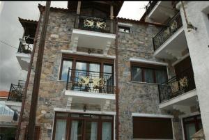 un edificio de ladrillo con balcones y ventanas. en Nakaraki en Stení Dhírfios