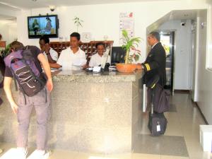 a man standing at a counter in a restaurant at Hotel Catimar in Maiquetía