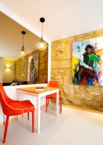 una sala da pranzo con tavolo, sedie e un dipinto di Almar Apartments a Póvoa de Varzim