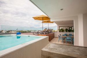 a swimming pool with a table and chairs and an umbrella at Hotelito del Mar Playa del Carmen in Playa del Carmen